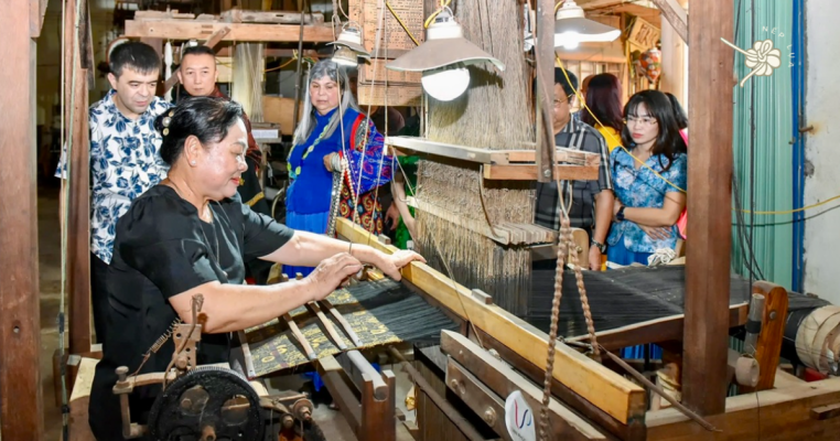 Du khách tham quan nghệ nhân dệt lụa 